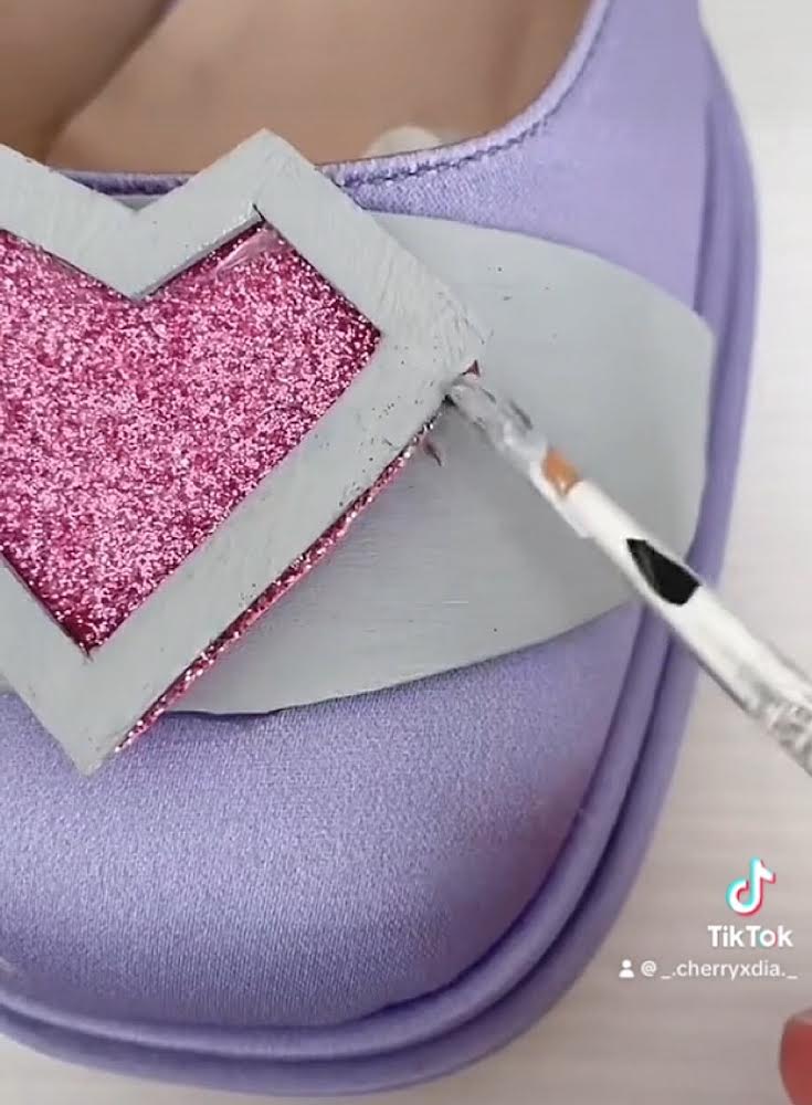 Dettaglio sulla realizzazione della decorazione a cuore sulle scarpe.